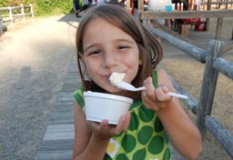 A girl happily eats ice cream